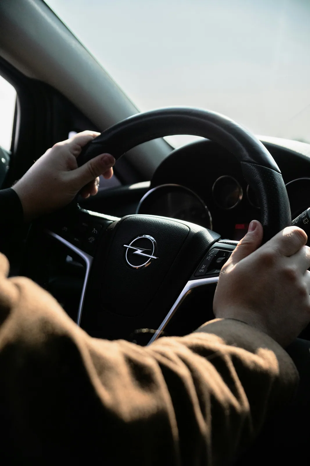 Hands gripping the steering wheel, ready to drive