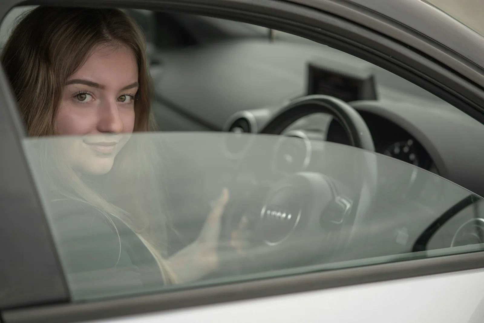 Smiling new learner driver at the wheel during a beginner driving course