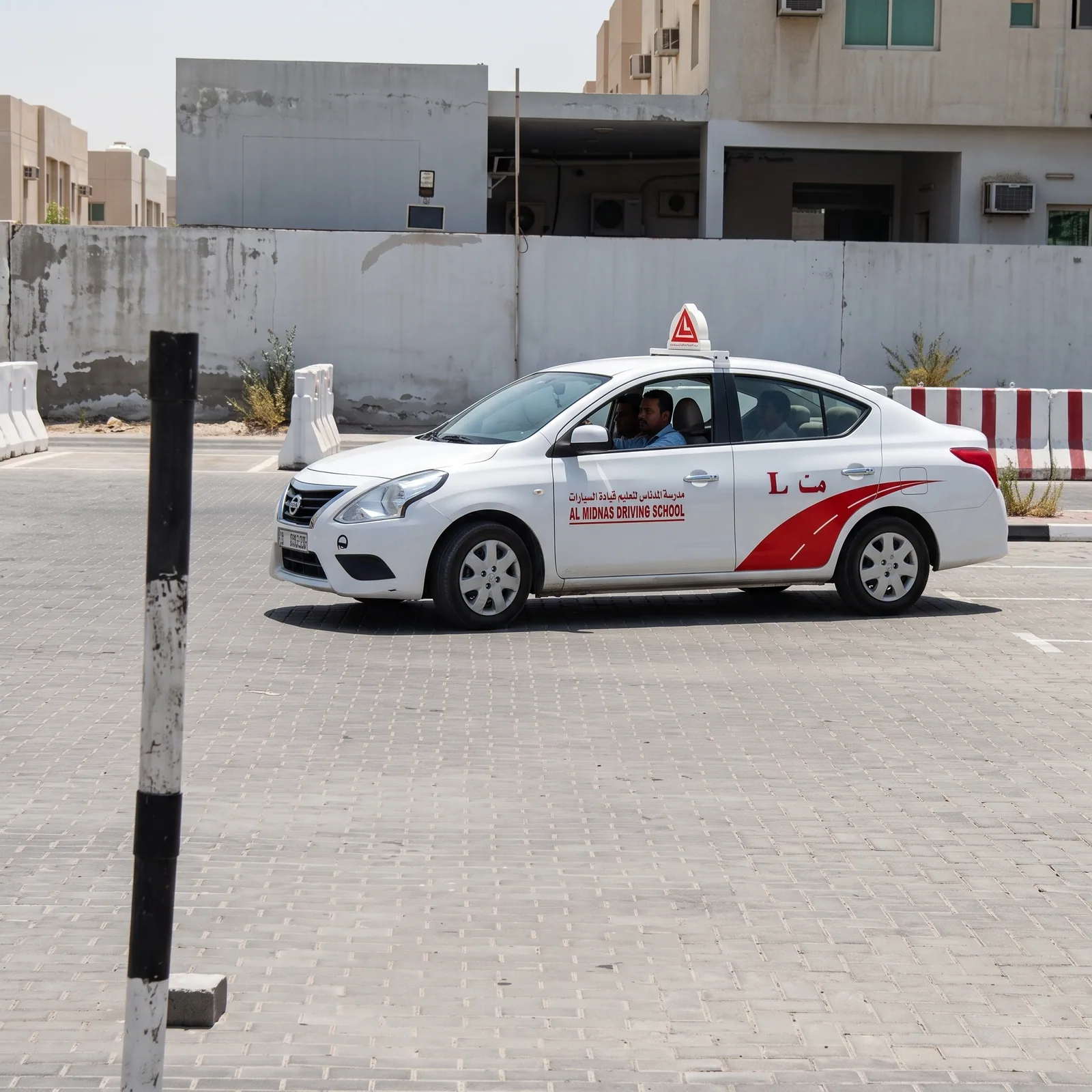 White driving school training car with an instructor and learner on the practice ground in Ajman
